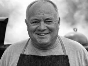 Black-and-white portrait of Earl 'The Rib Whisperer' Tatum, BBQ legend preparing perfect ribs in Kansas City, Missouri