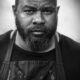 Black-and-white portrait of Travis 'Smoke Daddy' Wheeler, BBQ expert smoking brisket in Franklin, Tennessee