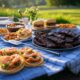 Father's Day BBQ feast featuring shrimp tacos, baked beans, ribs, and grilling tools on a picnic table
