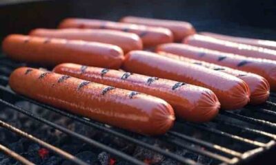Hot dogs on a grill with red, white, and blue 4th of July decorations