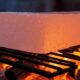 Heating a Himalayan Salt Block on a grill above flames.