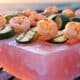 Himalayan salt block foods like shrimp and zucchini grilling.