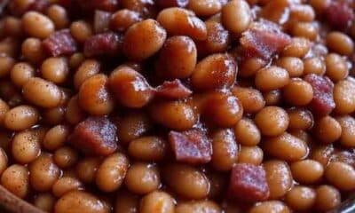 BBQ side dish recipe: Hearty baked beans with bacon and molasses, slow-cooked Kansas City style, with a Texas chili twist, served in a rustic bowl