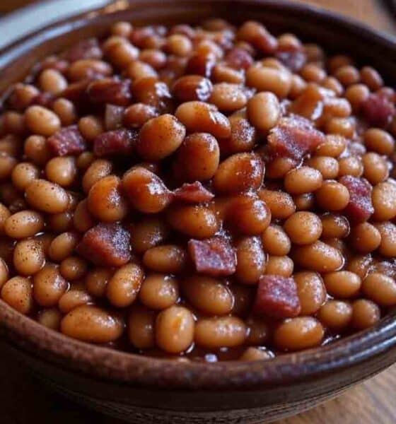 BBQ side dish recipe: Hearty baked beans with bacon and molasses, slow-cooked Kansas City style, with a Texas chili twist, served in a rustic bowl