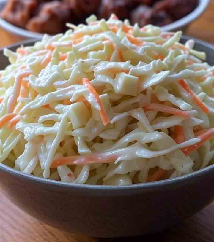 BBQ side dish recipes: Tangy coleslaw staple with shredded cabbage and carrots, dressed with vinegar and mayo, featuring a Memphis apple twist, served with BBQ meats