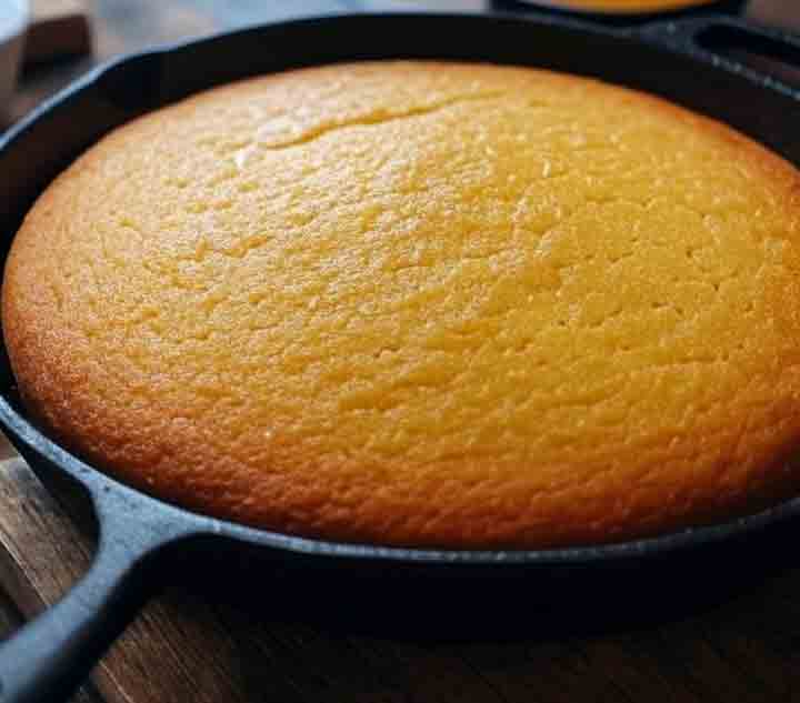 BBQ side dish recipes: Cornbread with golden crust in a cast-iron skillet, baked with buttermilk and bacon grease, served warm 