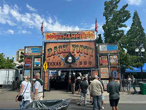 Back Forty Texas BBQ booth with championship banners at 2025 Rib Cook-Off