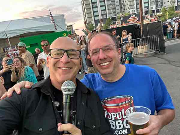 Sister Hazel lead singer Ken with a fan wearing a PopularBBQ.com shirt at 2025 Rib Cook-Off