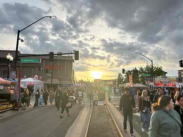 Sunset casting a golden glow over crowds and vendors at 2025 Rib Cook-Off