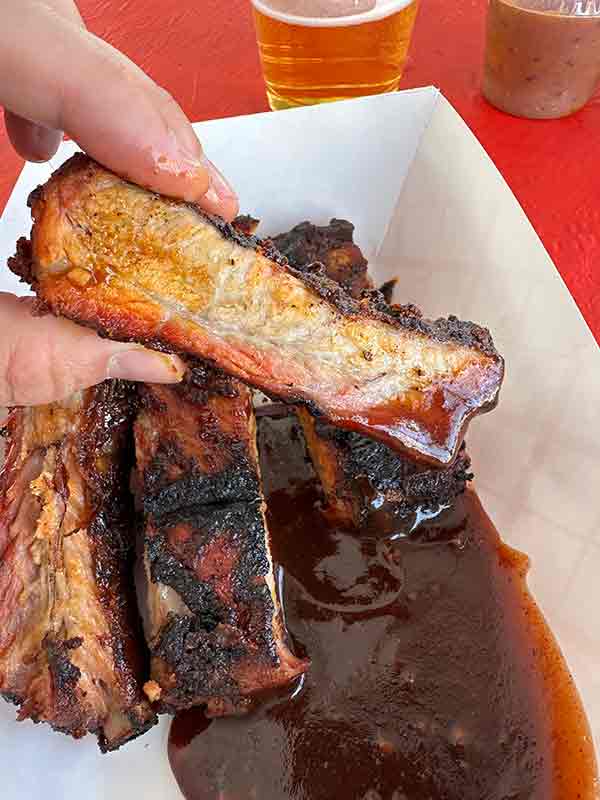 Close-up of glazed ribs in a takeout container from 2025 Rib Cook-Off