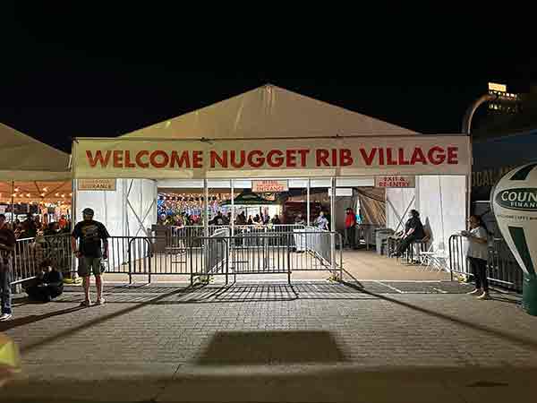 Night view of Welcome Nugget Rib Village entrance at 2025 Rib Cook-Off
