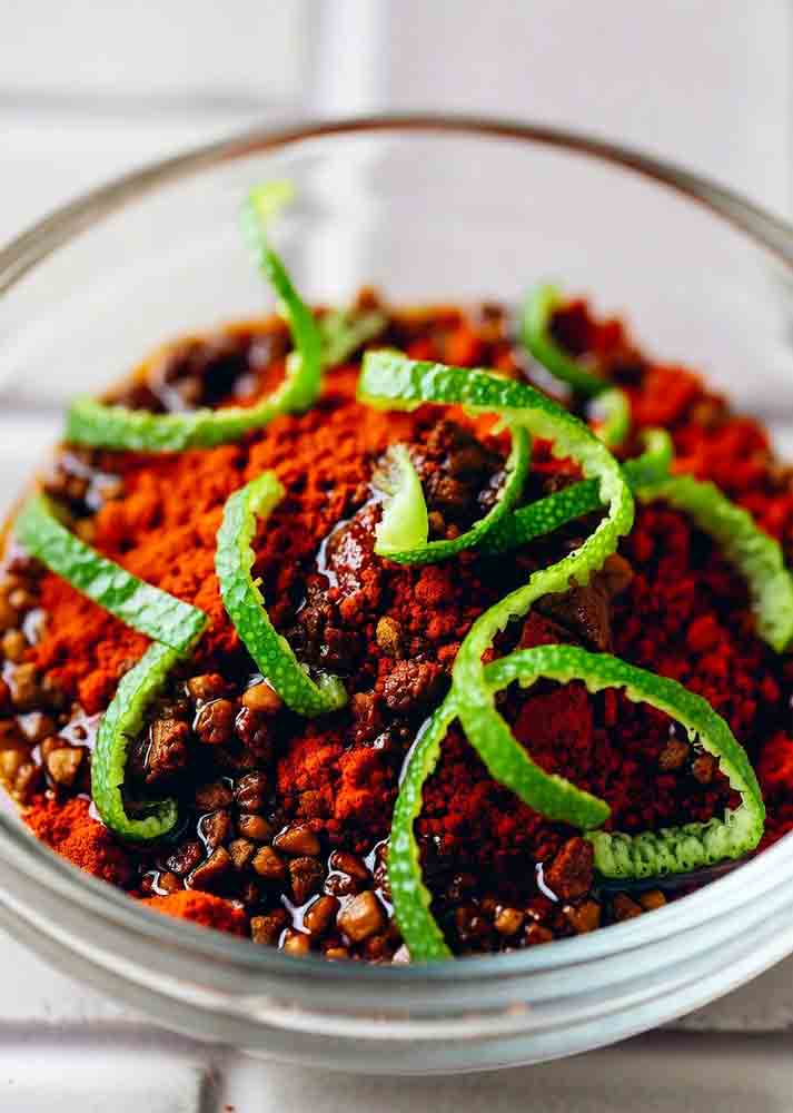 Lime zest and chili blend in grilling rub for fajitas, showcasing oil-bind hack for garlic-salt stick on flank steak