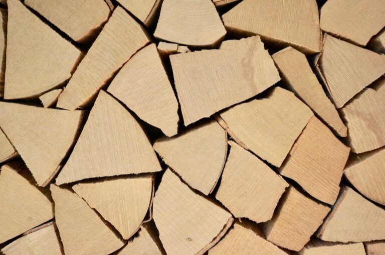 Stack of seasoned hardwood splits — smoking woods for the BBQ pitmaster wood-meat pairing guide