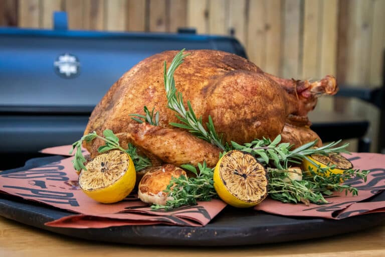 Whole smoked turkey with golden crispy skin on a pellet grill