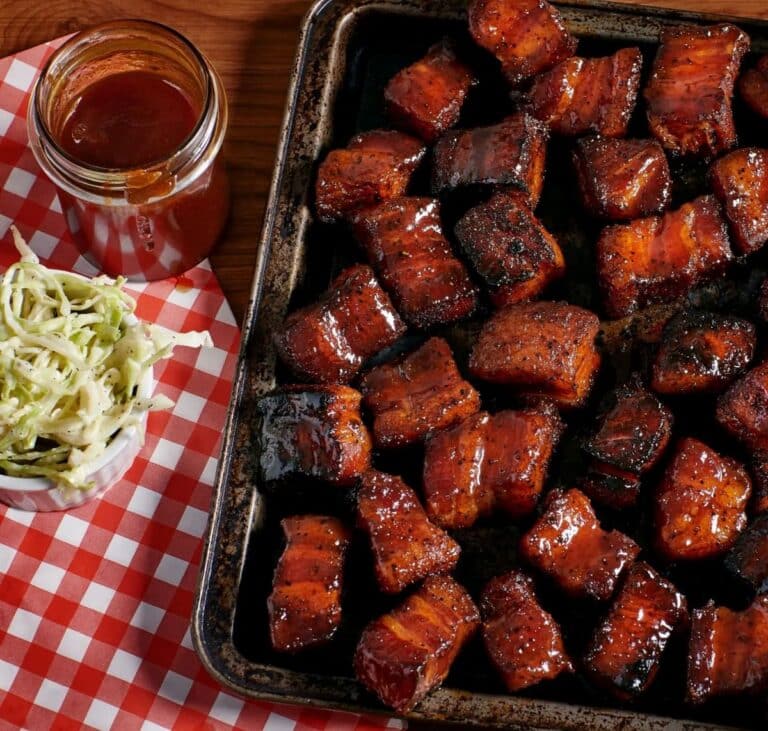 Glazed pork belly burnt ends stacked on a serving board