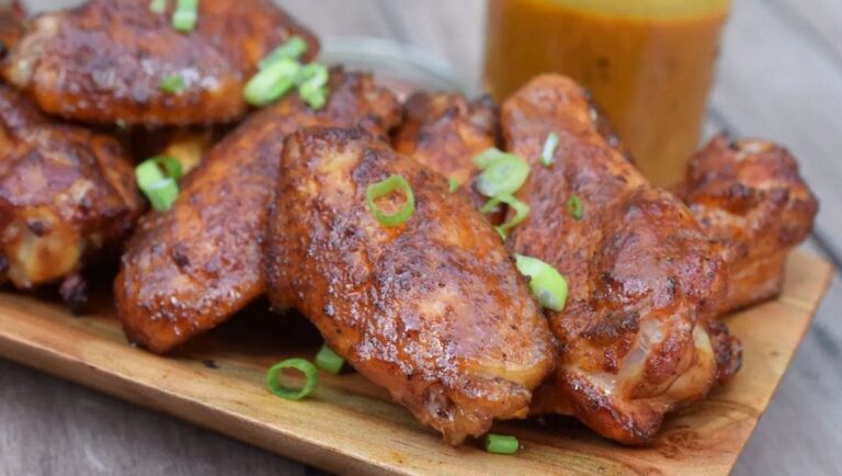 Applewood smoked chicken wings with crispy mahogany skin on the smoker