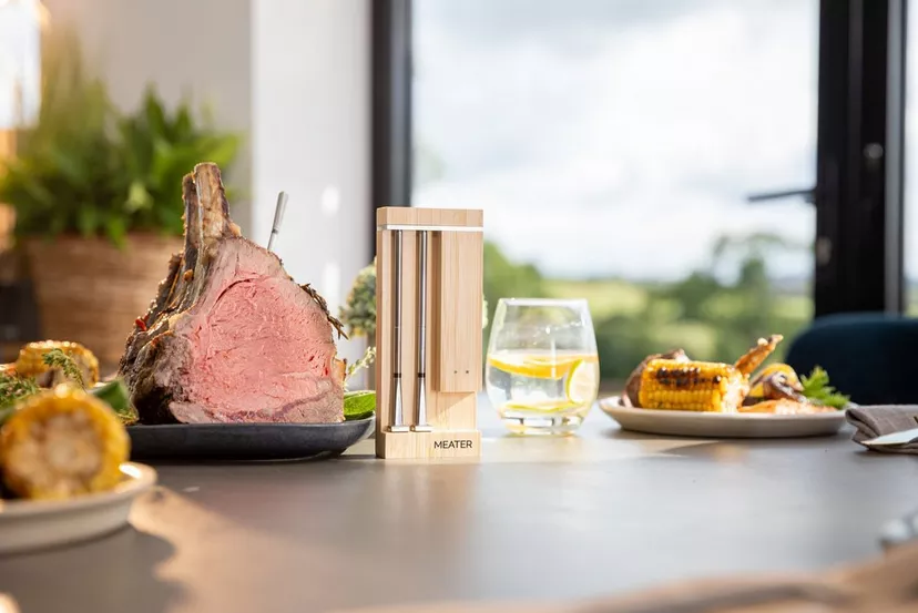MEATER-DUO_01 - Popular BBQ MEATER wireless meat thermometer probe in a rib roast, with its charging block on the counter